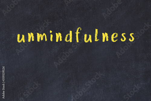 Black chalkboard with inscription unmindfulness on in photo