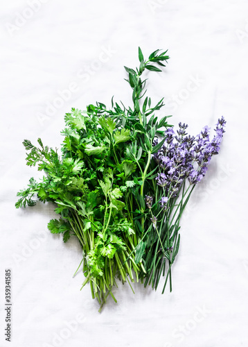 Fragrant garden herbs - tarragon, lavender, coriander cilantro on a light background, top view. Cooking food spices ingredients