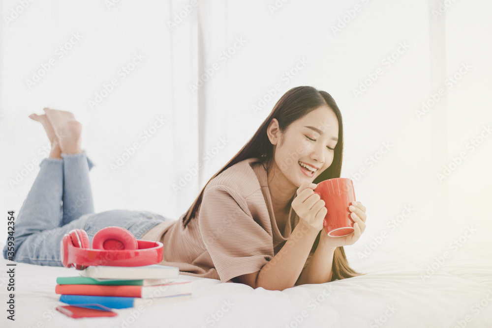 Happy asian beautiful woman drinking coffee on the bed in home Happy asian beautiful woman drinking coffee on the bed in home