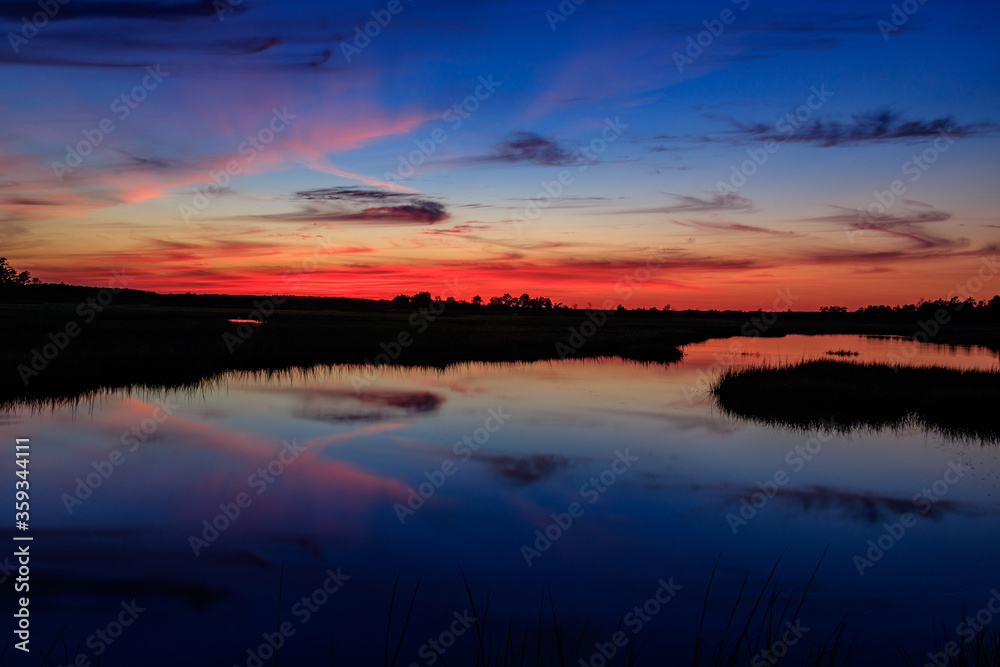 orange sunset over blue swamp water