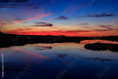 orange sunset over blue swamp water © The Camera Queen 