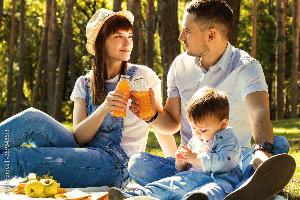 Family vacation. Father, mother and son having picnic in summer park