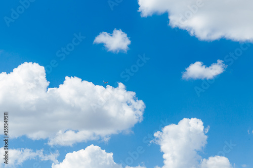 Blue clear sky with white fluffy clouds. Natural background