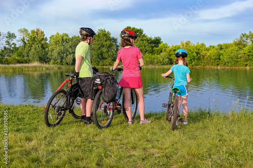 Family bike ride outdoors, active parents and kid cycling and relaxing outdoors near beautiful river, family sport and fitness 