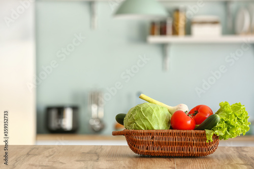 Basket with fresh vegetables on kitchen table