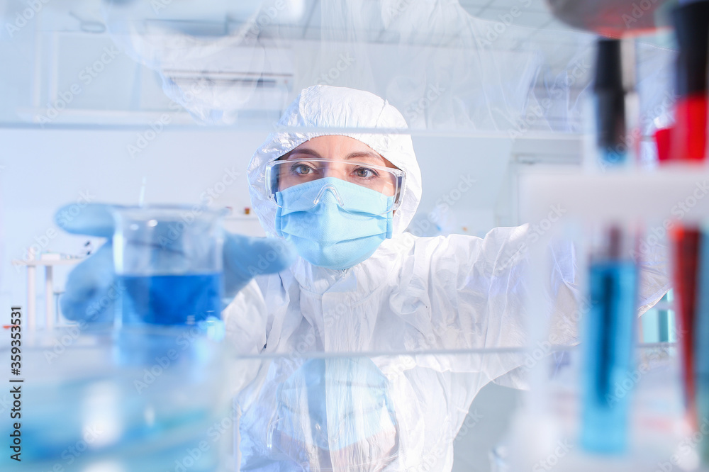 Fototapeta premium Scientist taking glassware from shelf in laboratory