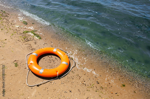 Bright lifebuoy ring on beach