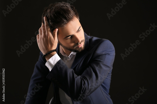 Handsome man with stylish hairdo on dark background