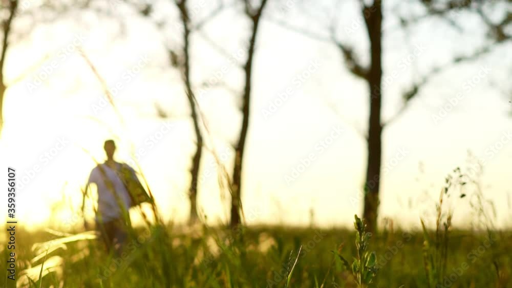 a man walks on a field at sunset a man walks on a field at sunset