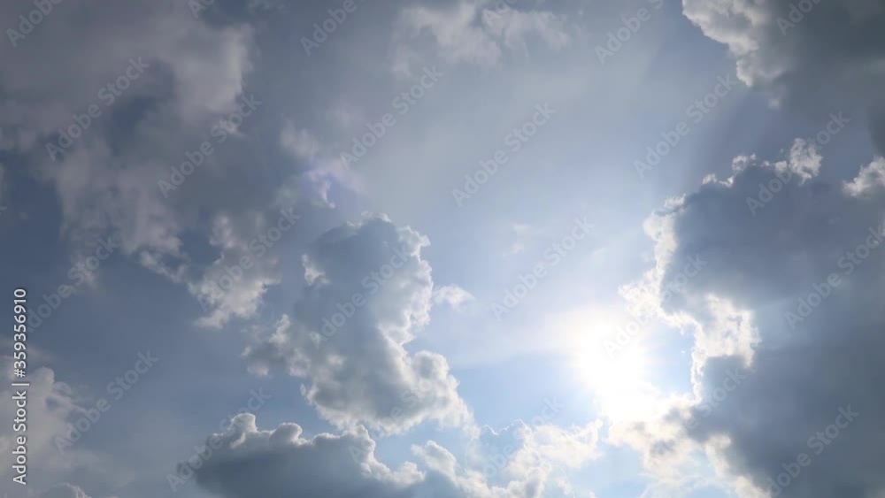 TimeLapse of beautiful sunny blue sky with bright sun light shining through white clouds & cumulus cloudscape in tropical summer or spring sunlight, sunbeam & sun ray flares at daylight sunshine day TimeLapse of beautiful sunny blue sky with bright sun light shining through white clouds & cumulus cloudscape in tropical summer or spring sunlight, sunbeam & sun ray flares at daylight sunshine day
