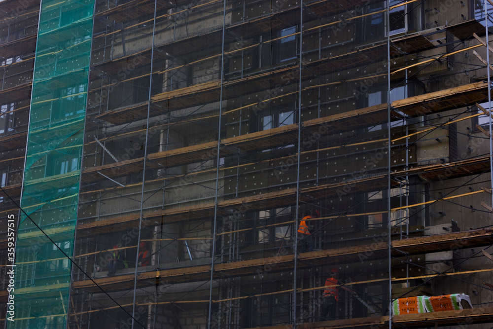 builders are building a multi-storey house. scaffolding and materials