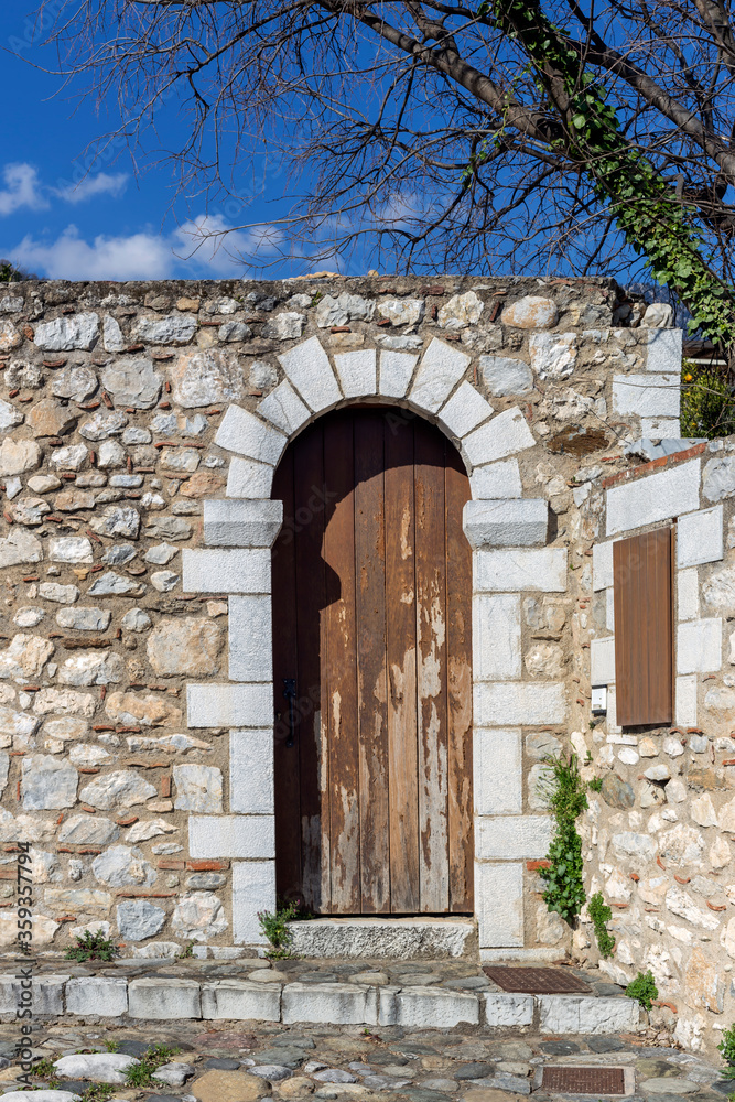 The background old, stone wall with wooden retro door