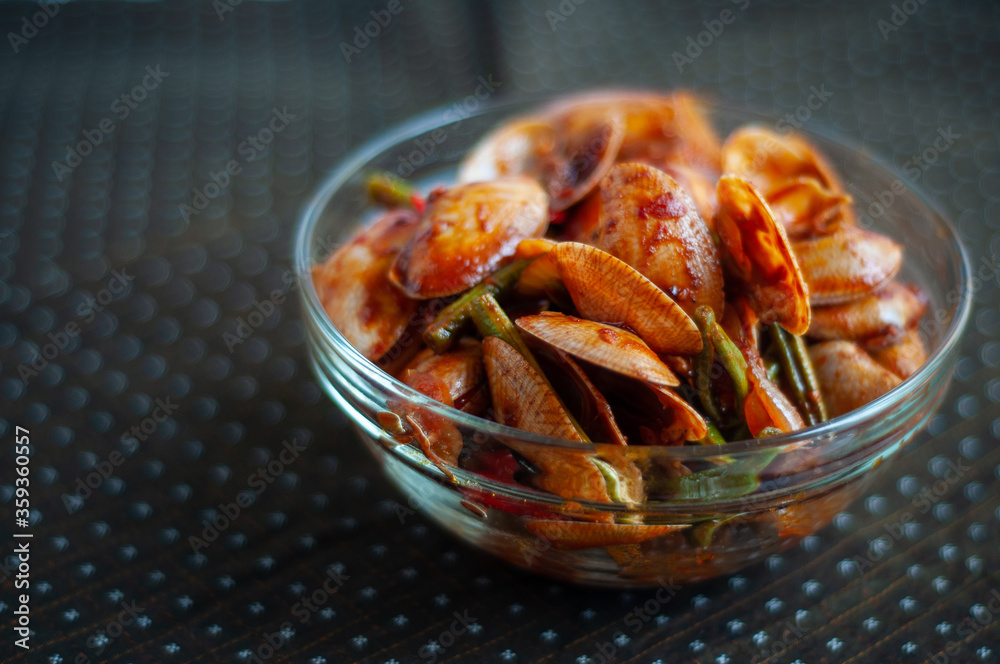 Spicy Paphia textile, or known as retak seribu lala fried with chillies. Served in a bowl. selective focus. Spicy Paphia textile, or known as retak seribu lala fried with chillies. Served in a bowl. selective focus.