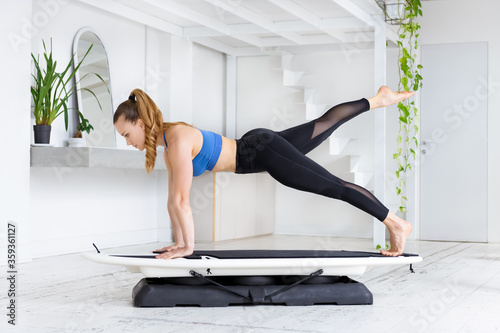 Woman doing a fit surf plank kick back photo