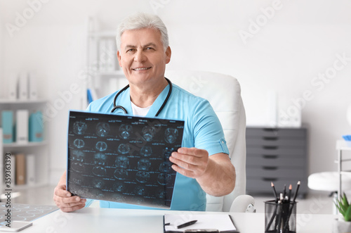 Senior neurologist with MRI scan of human head in clinic photo