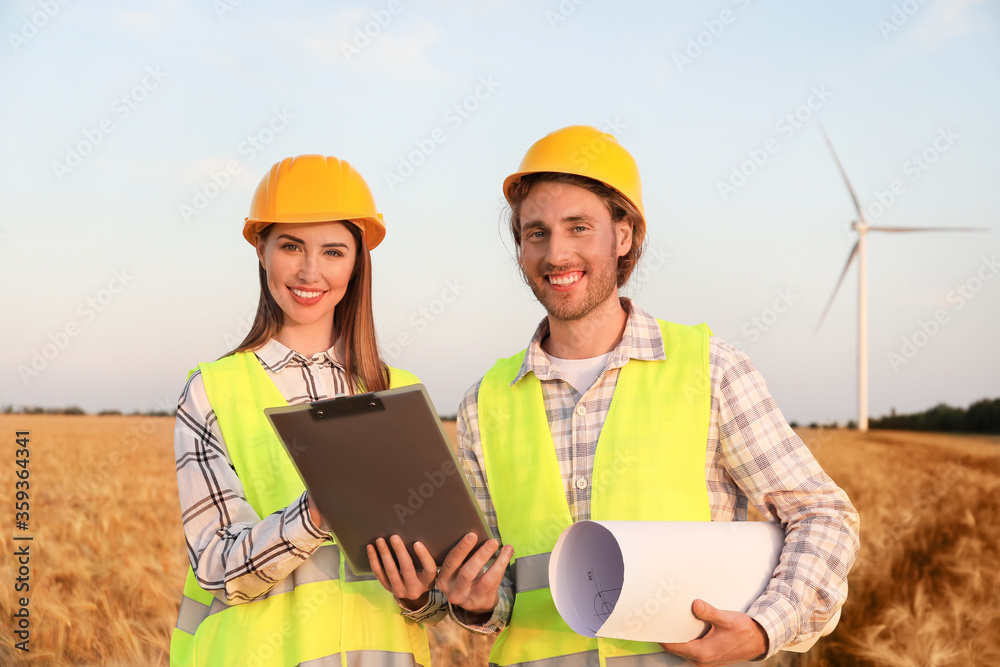 Engineers on windmill farm for electric power production Engineers on windmill farm for electric power production
