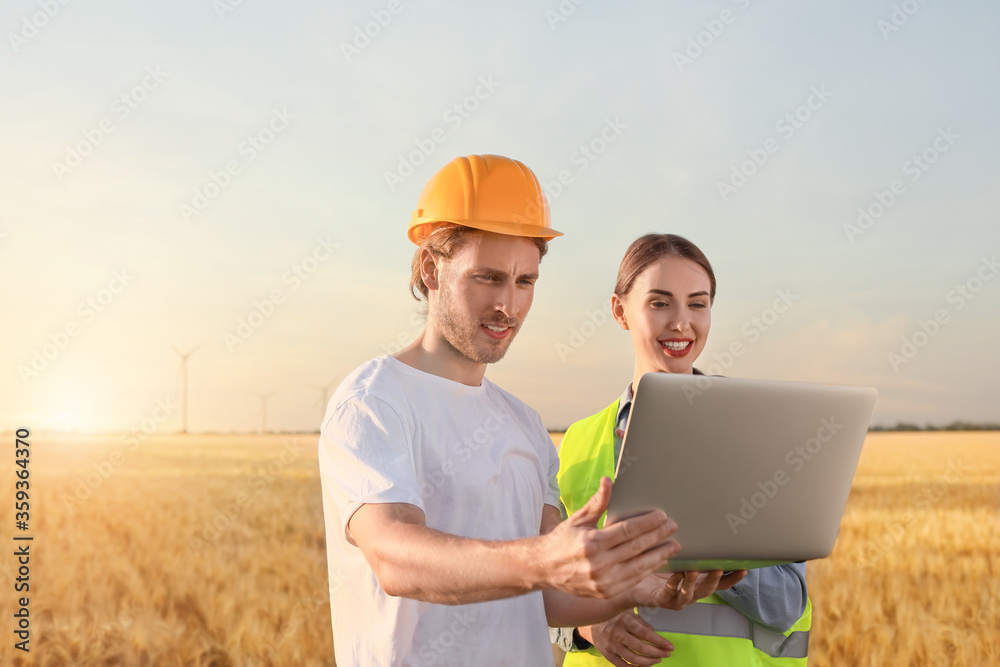 Engineers on windmill farm for electric power production Engineers on windmill farm for electric power production