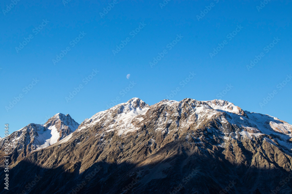 Half moon over the mountains. Aoraki Mt Cook National Park, Southwest New Zealand World. One of the top 10 hikes in South Island NZ. Spaces for you text. 