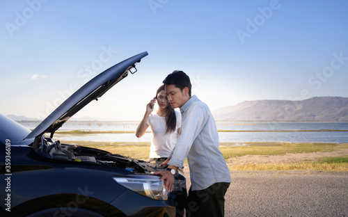 Couple on the road having problem with a car.Couple after a car breakdown at the side of the road