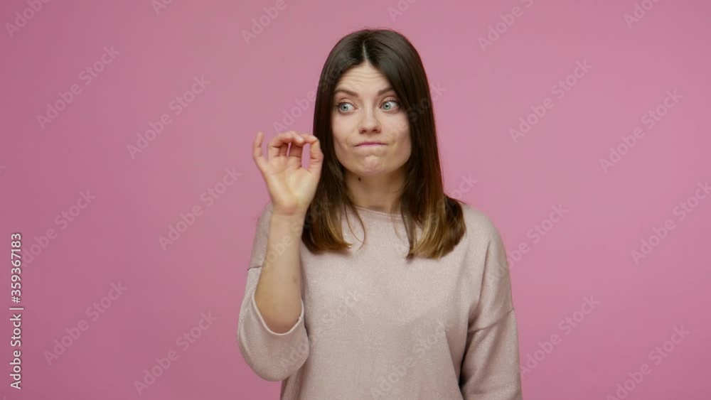 Brunette woman closing mouth with zip gesture, to keep silence, surprised by confidential information, promising don't tell anyone, keep secret forever. indoor studio shot isolated on pink background Brunette woman closing mouth with zip gesture, to keep silence, surprised by confidential information, promising don't tell anyone, keep secret forever. indoor studio shot isolated on pink background
