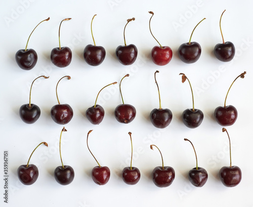 red cherry lies horizontally on a white background