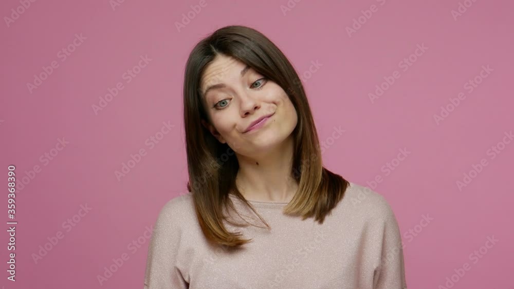 Closeup dumb woman making silly face with eyes crossed, fooling around with idiotic laughter, showing stupid brainless humorous facial expression. indoor studio shot isolated on pink background Closeup dumb woman making silly face with eyes crossed, fooling around with idiotic laughter, showing stupid brainless humorous facial expression. indoor studio shot isolated on pink background