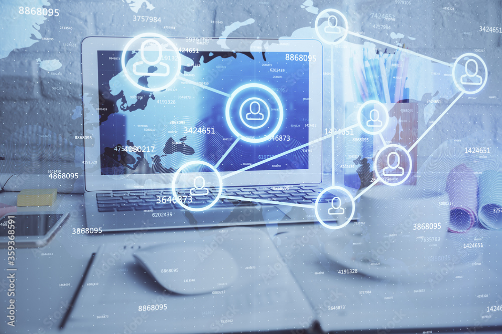 Computer on desktop with social network hologram. Multi exposure. Concept of international people connections.