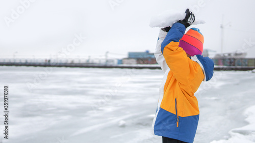 Boy playing outdoors in winter scenery. Winter activities for kids