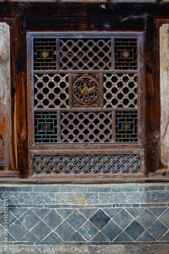 Traditional Chinese wooden sculpture on vintage windows. 
