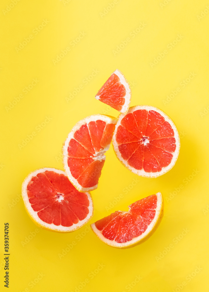 Orange slices in the air on yellow background.
Orange slices in the air on yellow background.
