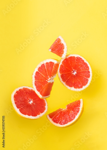 Orange slices in the air on yellow background. 