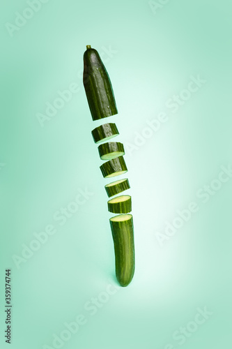 Sliced   cucumber in the air on blue background.