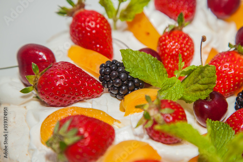 Fototapeta Naklejka Na Ścianę i Meble -  Beautiful dessert with berries: cherries, strawberries, blackberries, peaches and mint