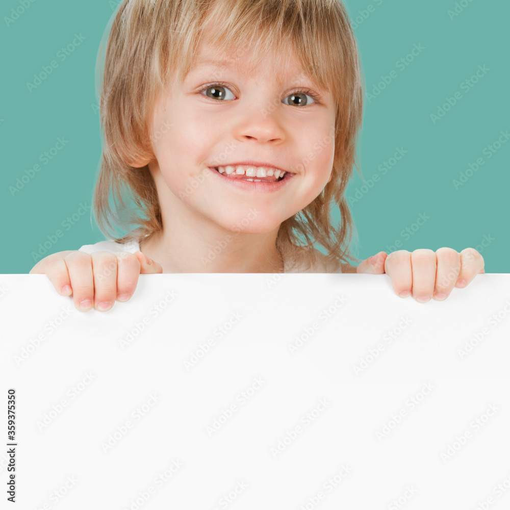 Cheerful smiling boy with empty white card, copy space for advertising and text