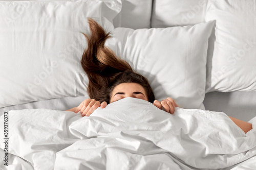 Fotografie people, bedtime and rest concept - woman lying in bed under white blanket or duv