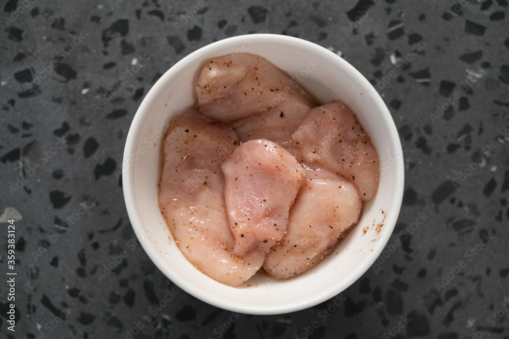 raw sliced chicken fillet meat in spices marinating in bowl raw sliced chicken fillet meat in spices marinating in bowl