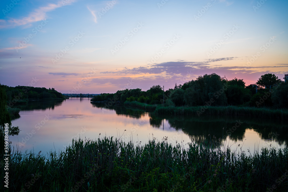 beautiful evening landscape. sunset on river. calm water in pond.