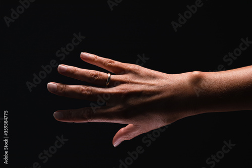 Woman’s arm on the black background.
