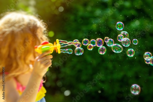 bubble. little girl blowing bubbles in the summer