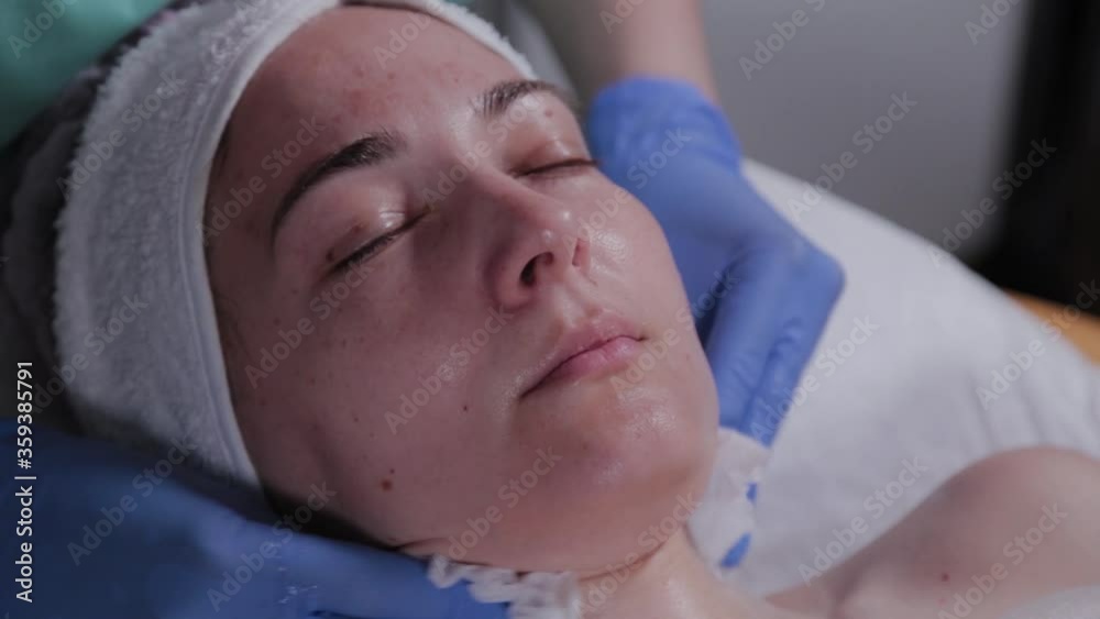 Professional beautician washes the mask off the face of a woman. Professional beautician washes the mask off the face of a woman.