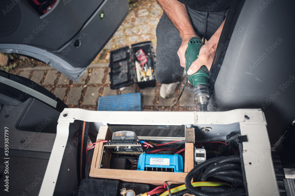 DIY camper van conversion - a hole gets drilled into the base of a seat DIY camper van conversion - a hole gets drilled into the base of a seat