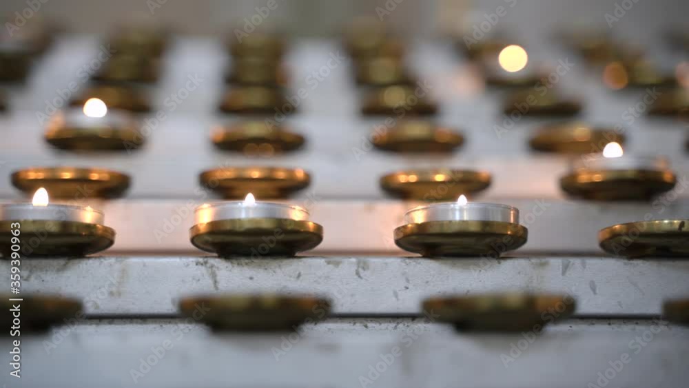 Church or memorial candles burning in the church. Golden flame candle on blurred background Church or memorial candles burning in the church. Golden flame candle on blurred background