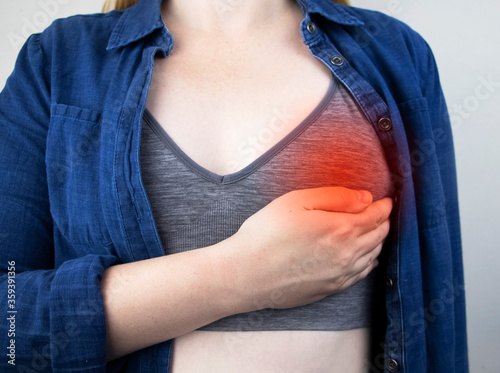 A woman suffers from chest pain. On examination by a gynecologist-mammologist. The concept of the prevention of breast diseases, cancer, mastopathy or hormonal disorders photo