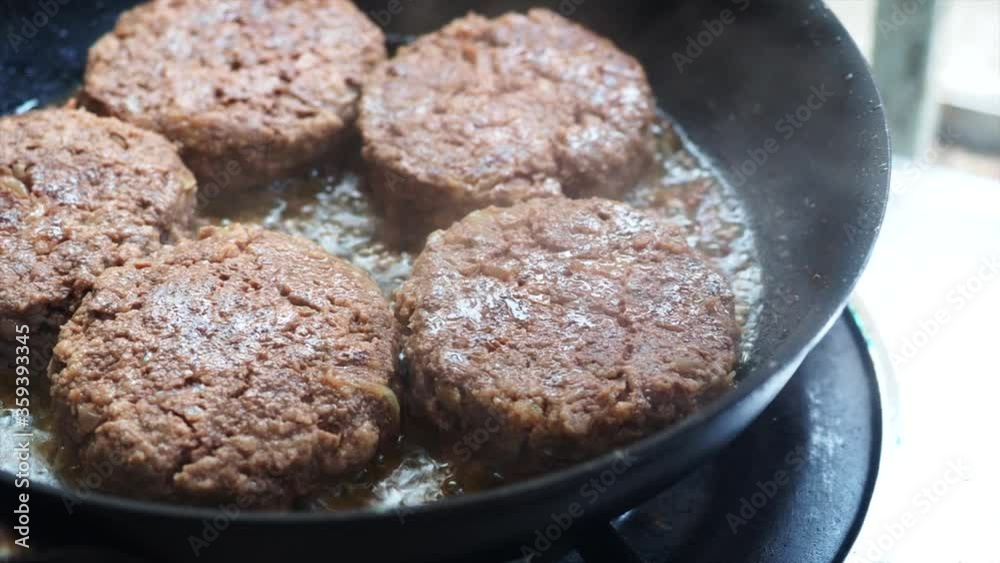 Beef burgers fried in frying pan. Close-up homemade juicy minced meat patties burgers in iron frying pan top view. Beef burgers fried in frying pan. Close-up homemade juicy minced meat patties burgers in iron frying pan top view.
