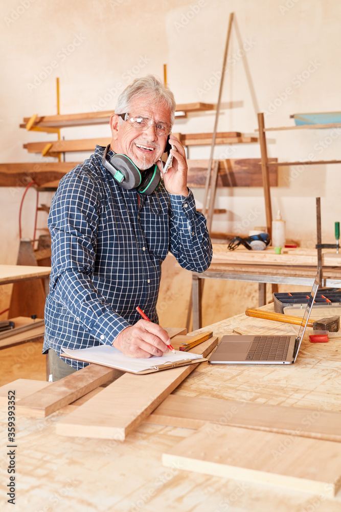 Old craftsman with mobile phone and checklist