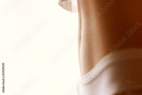 Beautiful slim female belly. Part of the body of a girl in white panties and top. Copy space.