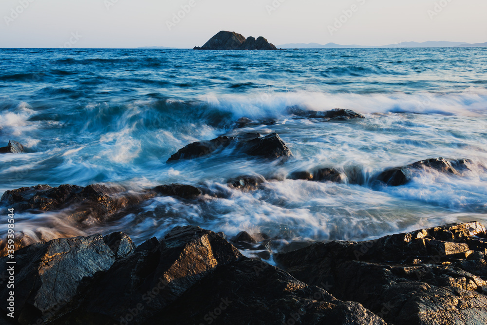 Obraz premium Rocks on the beach, long exposure to the sea and rocks, waves hitting the rocks.