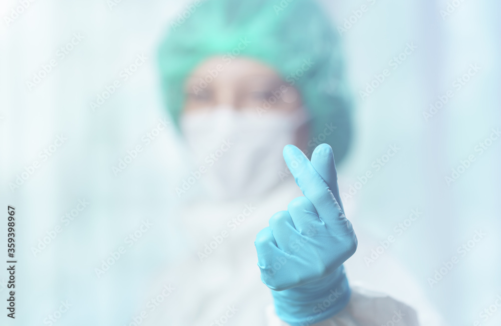 Asian female doctor wearing hazmat suit make a mini heart sign hand.
