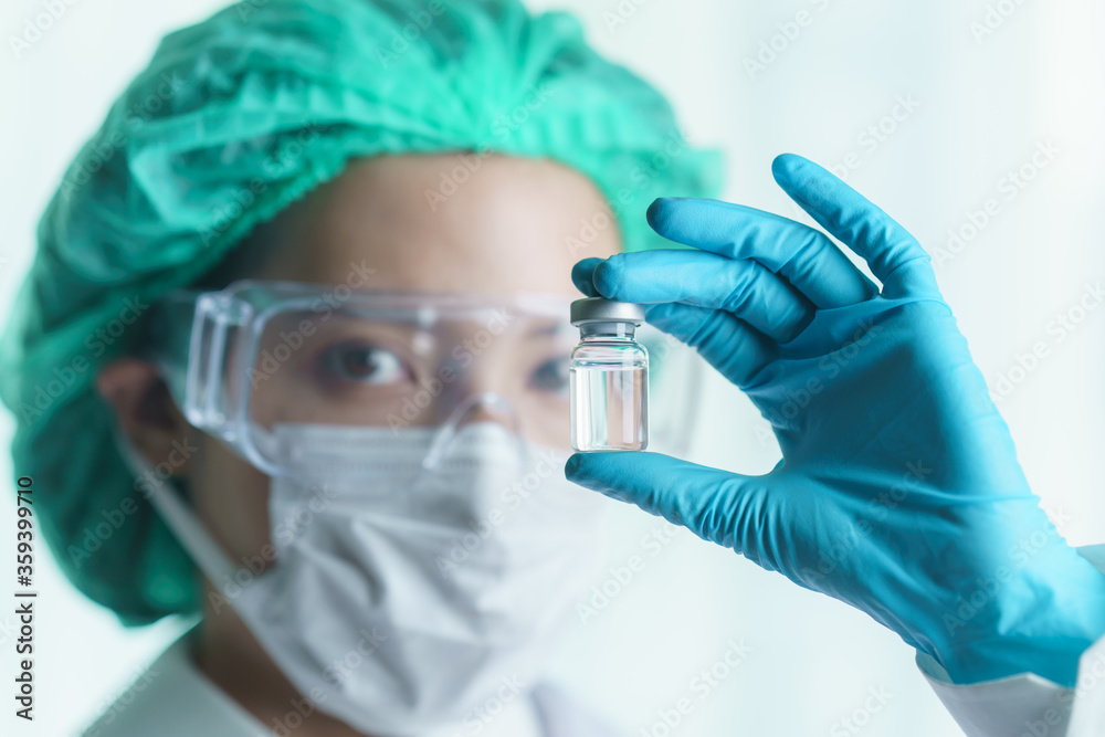 Woman doctor holding vaccine or medicine in transparent glass on her hand. Woman doctor holding vaccine or medicine in transparent glass on her hand.