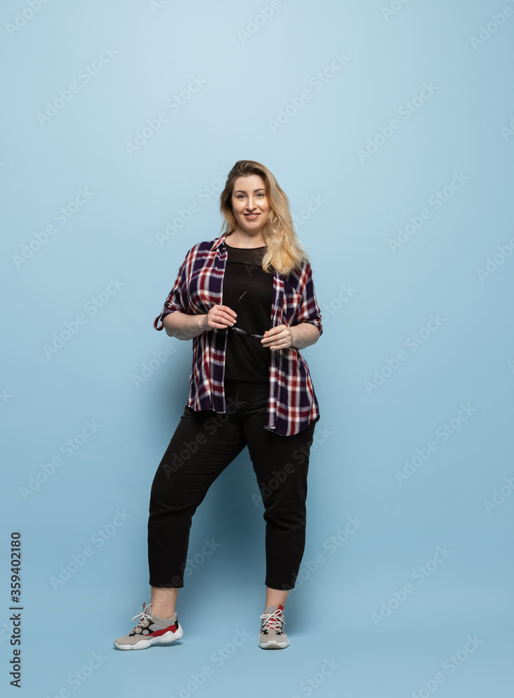 Fashionable, stylish. Young woman in casual wear on blue background. Bodypositive character, feminism, loving herself, beauty concept. Plus size businesswoman, beautiful girl. Inclusion, diversity. Fashionable, stylish. Young woman in casual wear on blue background. Bodypositive character, feminism, loving herself, beauty concept. Plus size businesswoman, beautiful girl. Inclusion, diversity.
